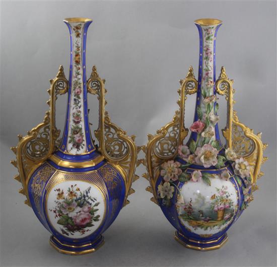 A pair of French jewelled and flower encrusted porcelain bottle vases
